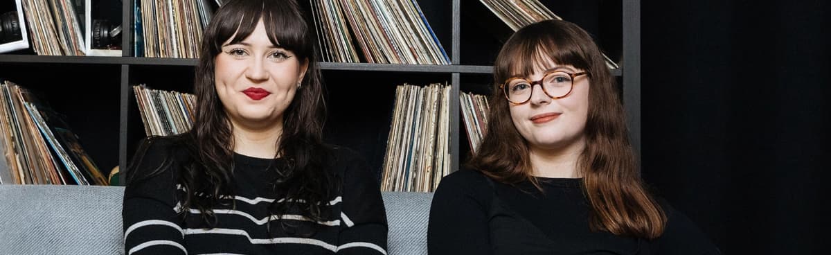 Los investigadores musicales se sientan frente a una colección de discos de vinilo.